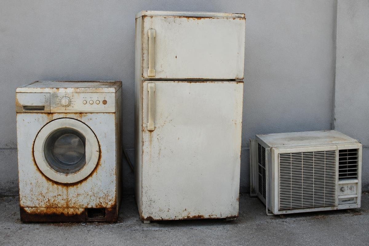 Old washing machine, refrigerator and air conditioner kept out for appliance scrap pickup